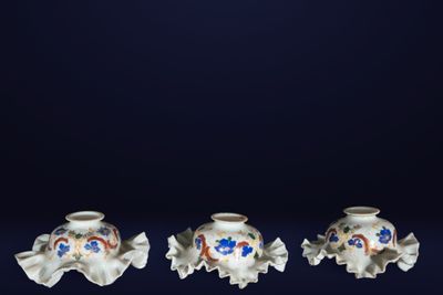 trois petits vases sont posés sur une table devant un fond sombre