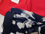 two red shirts and a blue and white skirt with a price tag