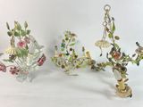 three glass vases with flowers on them on a white surface