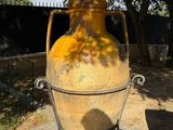 a large yellow vase that is sitting on a stand