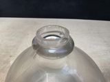 a clear glass bottle with a small hole in it
