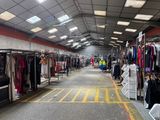 de nombreux portants de vêtements exposés dans un grand entrepôt
