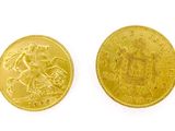 a close up of two gold coins on a white surface