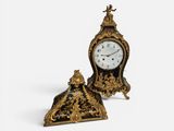 une petite horloge posée à côté d'une autre horloge, encore plus petite