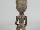 wooden figurine of a man holding a cup on a white background