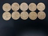 a group of six british coins sitting on top of a black surface