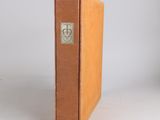 an old book sitting on top of a white table next to a white wall