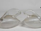 pair of clear glass ducks with metal beaks on a white surface
