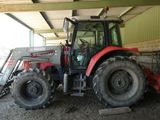 un tracteur rouge garé dans une grange