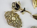 three pieces of brooches and a spoon on a white surface