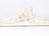 a statue of two children laying on the ground