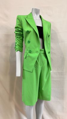 the mannequin is wearing a bright green suit and black top