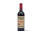 a bottle of red wine sitting on top of a white table