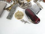 a lot of silver and gold jewelry on a white table