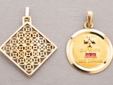 two gold pendants of different shapes and sizes on a gray surface