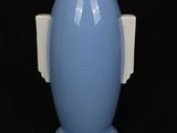 a blue vase with a white handle on a black background