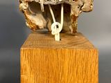 an image of a sculpture of a wooden block with a metal object on top of it