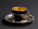 a cup and saucer sitting on a black table