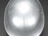 a silver helmet on a black surface