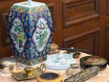 un vase bleu et blanc posé sur une table où se trouvent d'autres objets