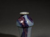 un petit vase orné d'un motif bleu et violet