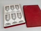six wine glasses in a red box on a white table