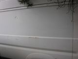 a white van with a bunch of plants growing on the side of it