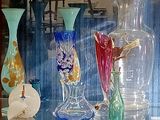 de nombreux vases en verre de différentes couleurs exposés dans une vitrine