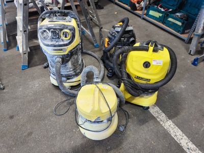 deux aspirateurs posés par terre dans le garage