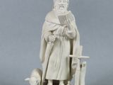 une statue représentant un homme assis sur une chaise en train de lire un livre