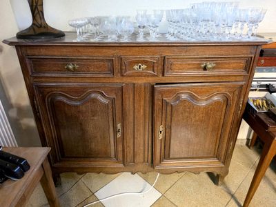 a wooden cabinet with a marble top and a lamp on top of it