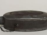 a metal object with a chain around it on a white surface