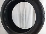 a close up of a tire on a white surface with a curtain in the background