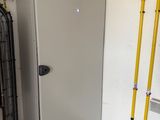 an image of a refrigerator in a garage with tools on the floor