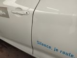 a white car with a blue sticker on the side of it