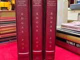 three books that are sitting on a red carpet
