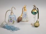 trois types différents de flacons de parfum posés sur une surface blanche