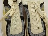 pair of white and black sneakers with laces on them on a white surface