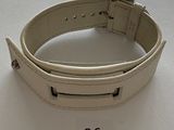 a white leather bracelet with a metal buckle on it