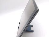 a tablet computer sitting on a stand on a white surface