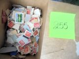 une boîte pleine de timbres et un post-it par terre
