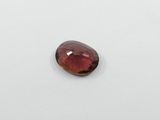 a red garnet stone on a white surface