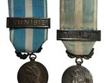 deux médailles sont représentées sur un fond blanc, accompagnées d'un ruban bleu et blanc