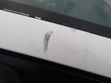 a close up of a car door handle with a small piece of paint on it