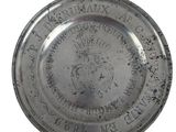 an old silver plate with a crown on it on a white background