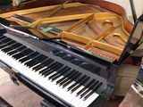 a piano that is sitting in a room next to a chair
