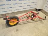 a small red cart with a yellow wheel on the floor