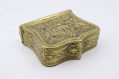 une boîte ancienne en laiton ornée d'un motif floral sur le couvercle