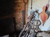 a broken toilet in the corner of a room with tools