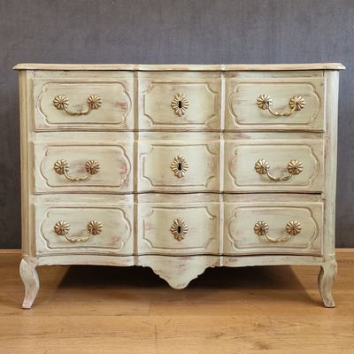 a white chest of drawers on a wooden floor
